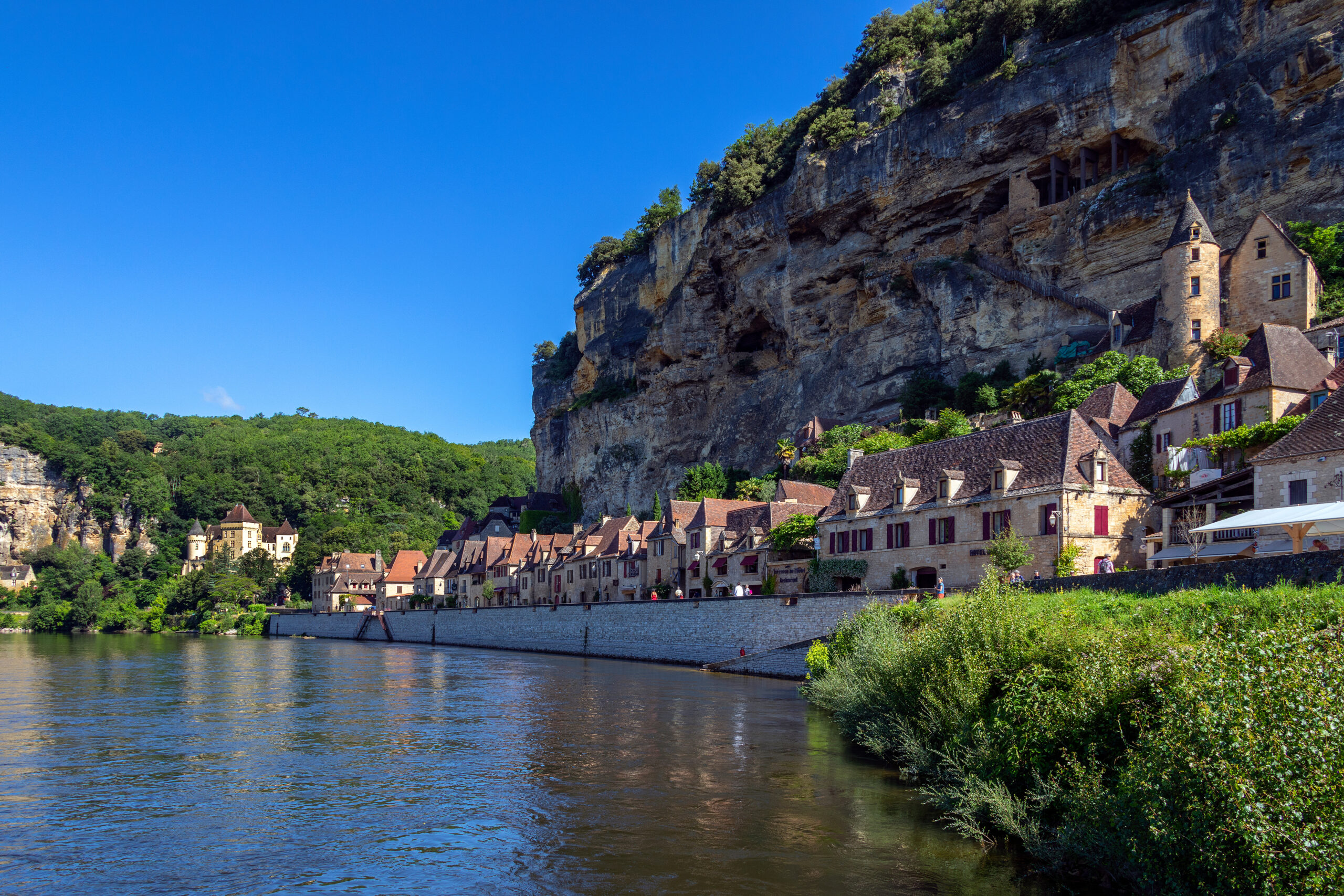 The village of La Roque-Gageac, Chateau de la Malartrie and the Dordogne River. This pictursque village is in the Dordogne department of the Nouvelle-Aquitaine region of southwestern France.